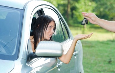 Woman in car being handed car keys